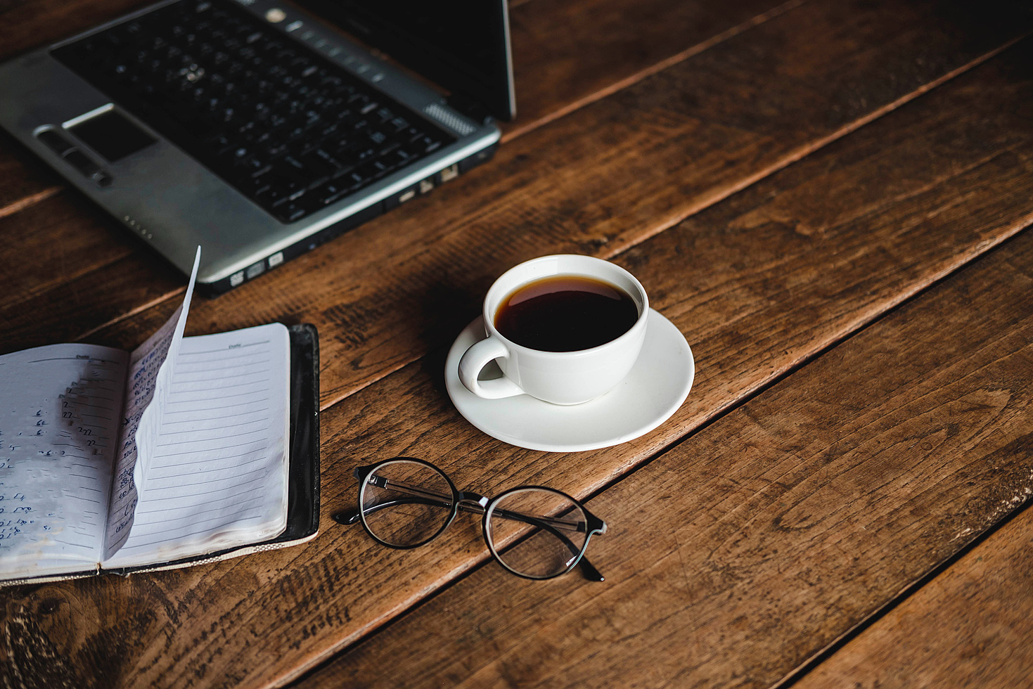 Coffee Cup, Notebook, and Laptop on a Desk
